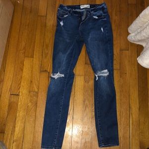 Distressed dark blue jeans